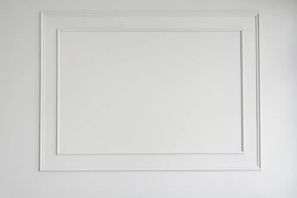 Mur blanc avec moulures décoratives rectangulaires doubles, style classique et épuré pour décoration d'intérieur chic.